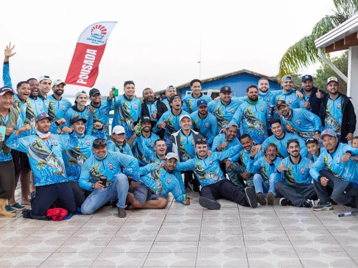 Grupo grande de pescadores em pousada vestindo camisetas azuis personalizadas